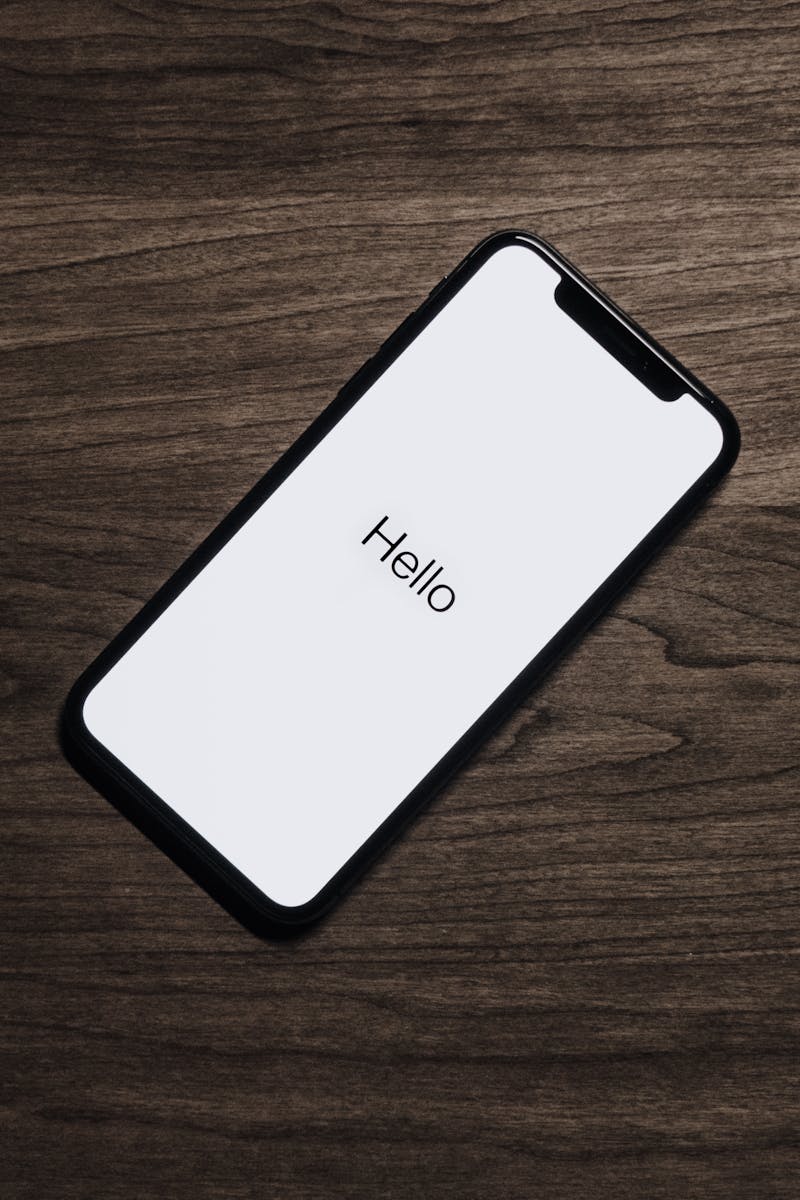 A smartphone displaying 'Hello' on a wooden surface, showcasing modern technology.